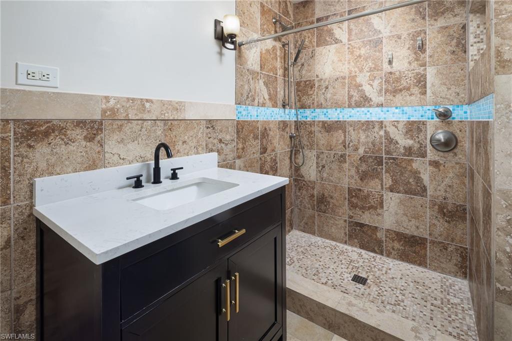 2424 Harbor Road Naples, FL 34104 - Photo 14 of 26 a bathroom with a sink and a mirror
