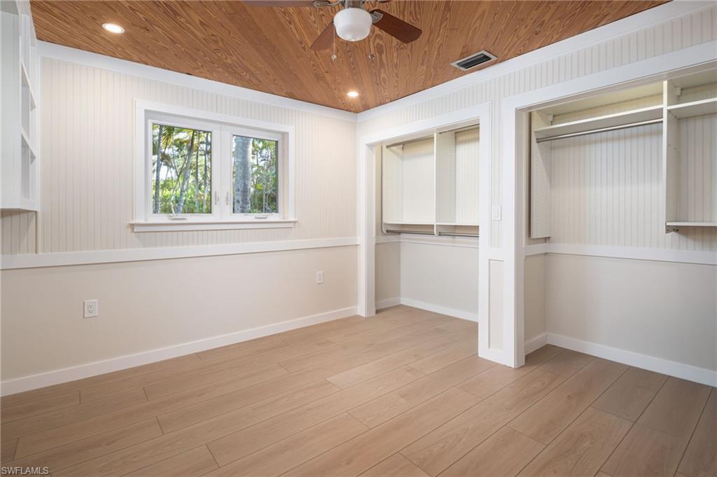 2424 Harbor Road Naples, FL 34104 - Photo 16 of 26 an empty room with wooden floor cabinet and windows