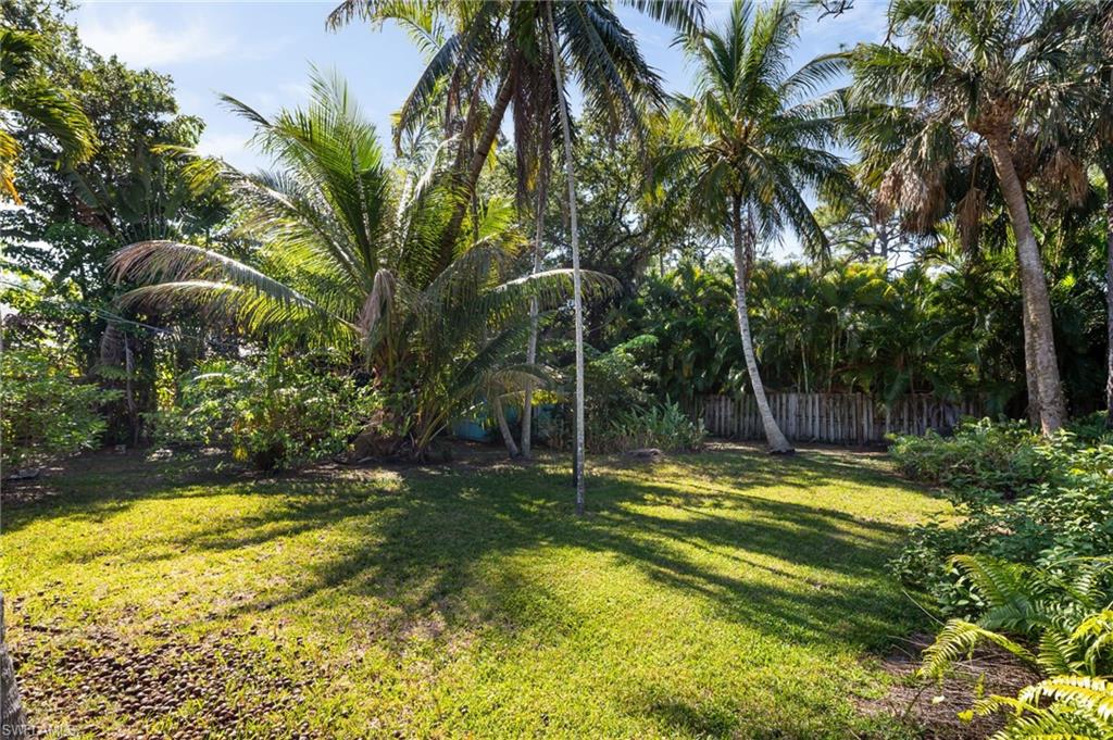 2424 Harbor Road Naples, FL 34104 - Photo 21 of 26 a view of a swimming pool with a garden and trees