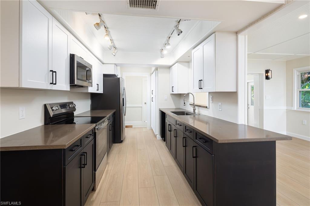 2424 Harbor Road Naples, FL 34104 - Photo 6 of 26 a kitchen with stainless steel appliances granite countertop a sink stove and refrigerator