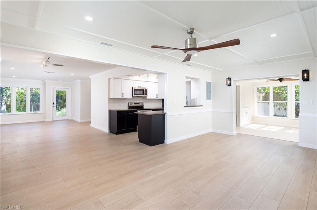 2424 Harbor Road Naples, FL 34104 - Photo 7 of 26 a view of a kitchen with a stove top oven a refrigerator a sink with wooden floor