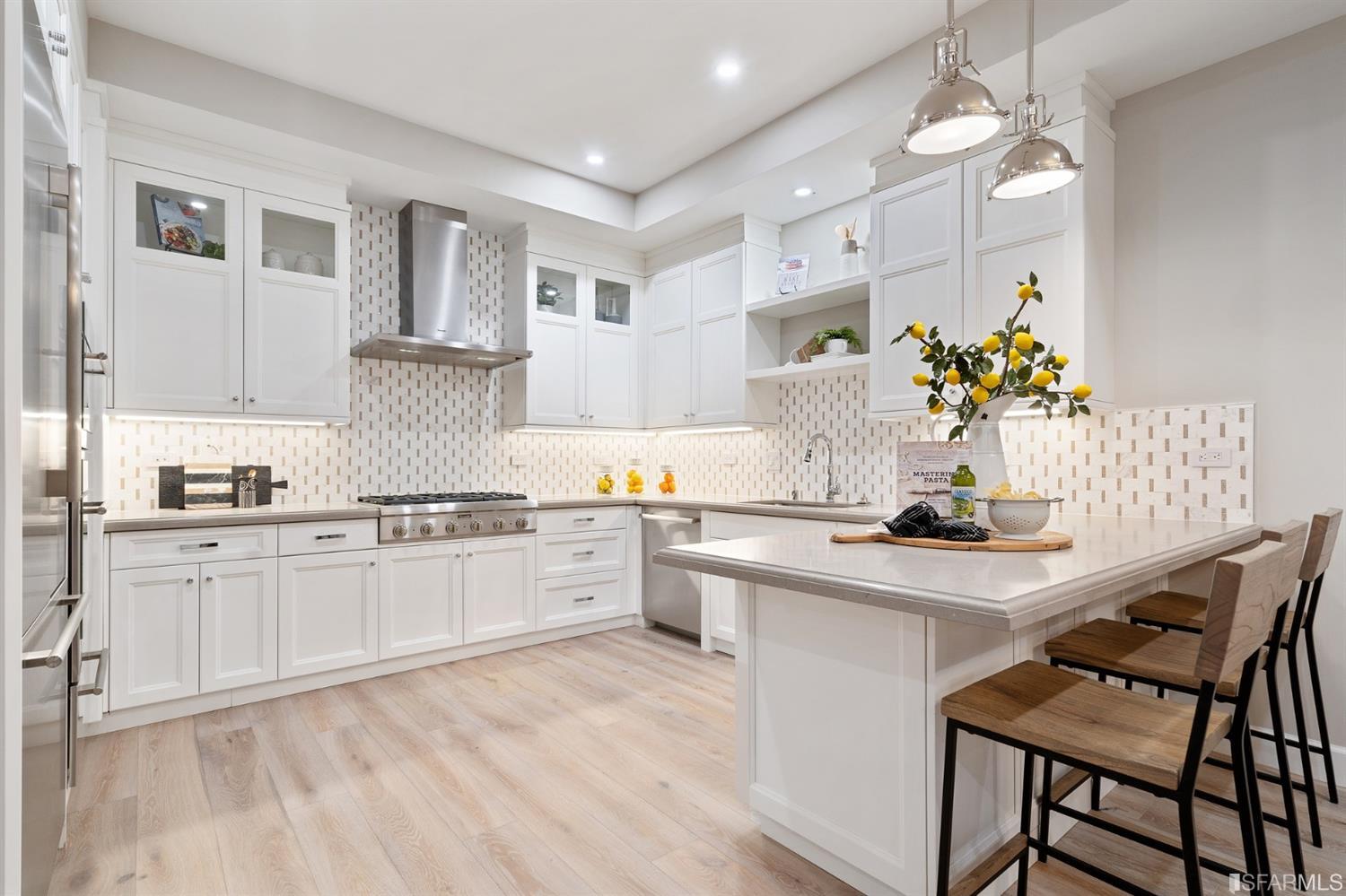 a kitchen with granite countertop white cabinets white appliances and chairs