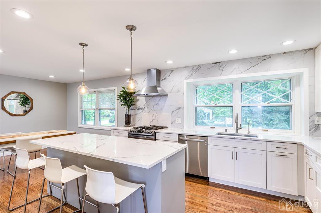 14 Tamarack Road Edison, NJ 08820 - Photo 12 of 40 a kitchen with a sink stove and white cabinets with wooden floor