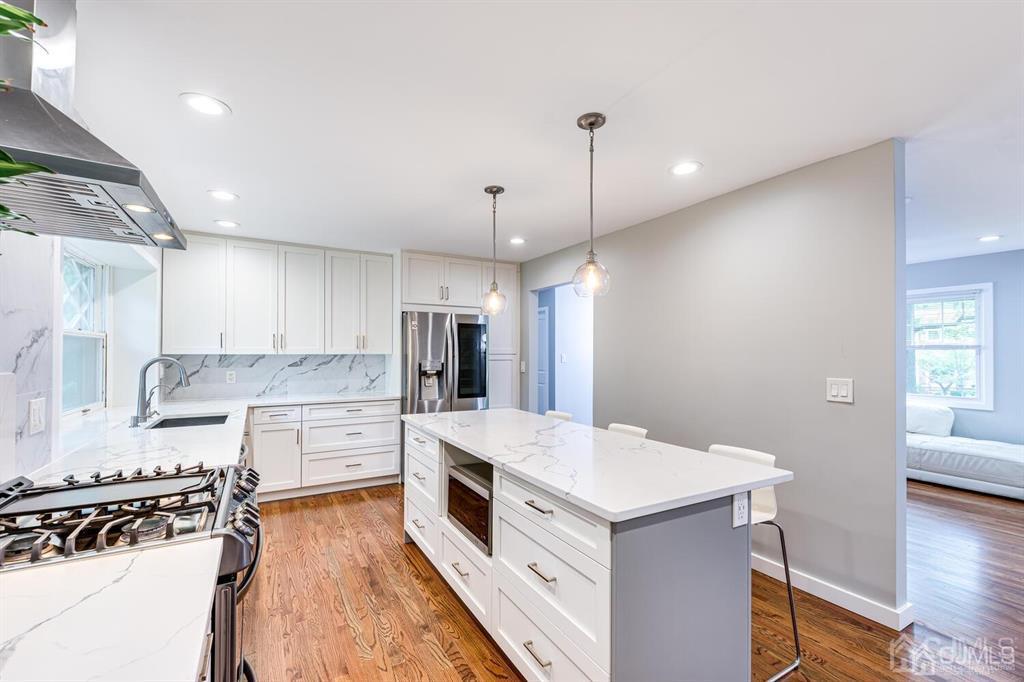 14 Tamarack Road Edison, NJ 08820 - Photo 13 of 40 a kitchen with a white center island a sink stainless steel appliances and cabinets