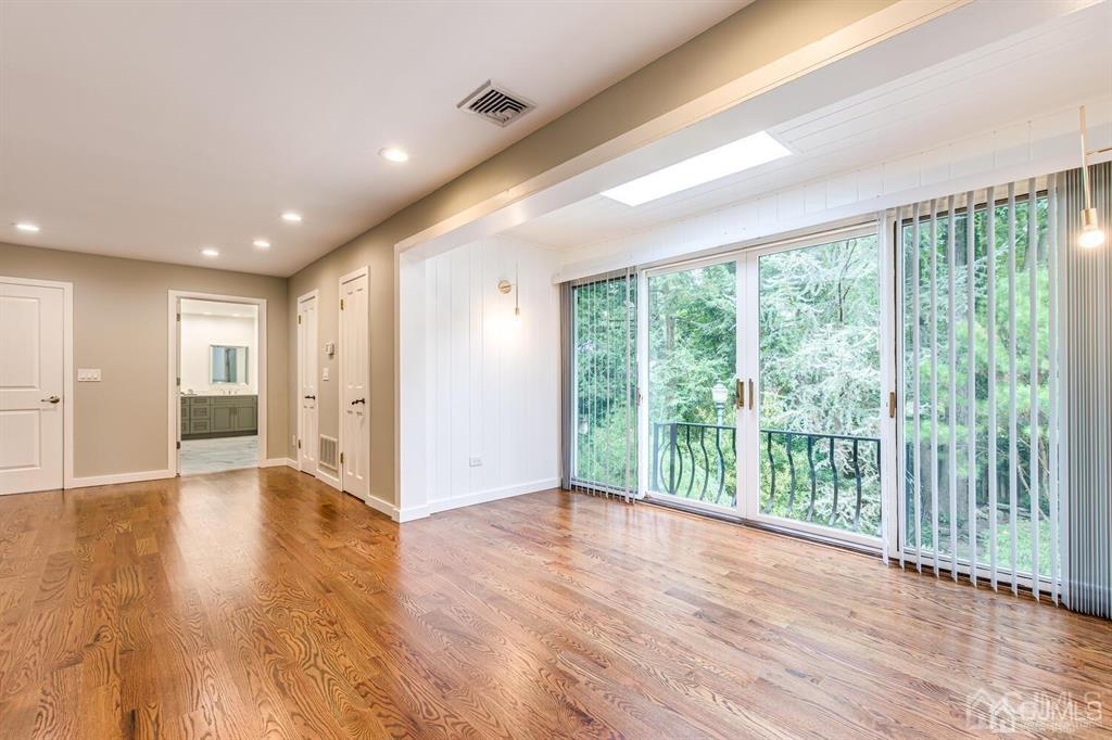 14 Tamarack Road Edison, NJ 08820 - Photo 19 of 40 a view of an empty room with wooden floor and glass door