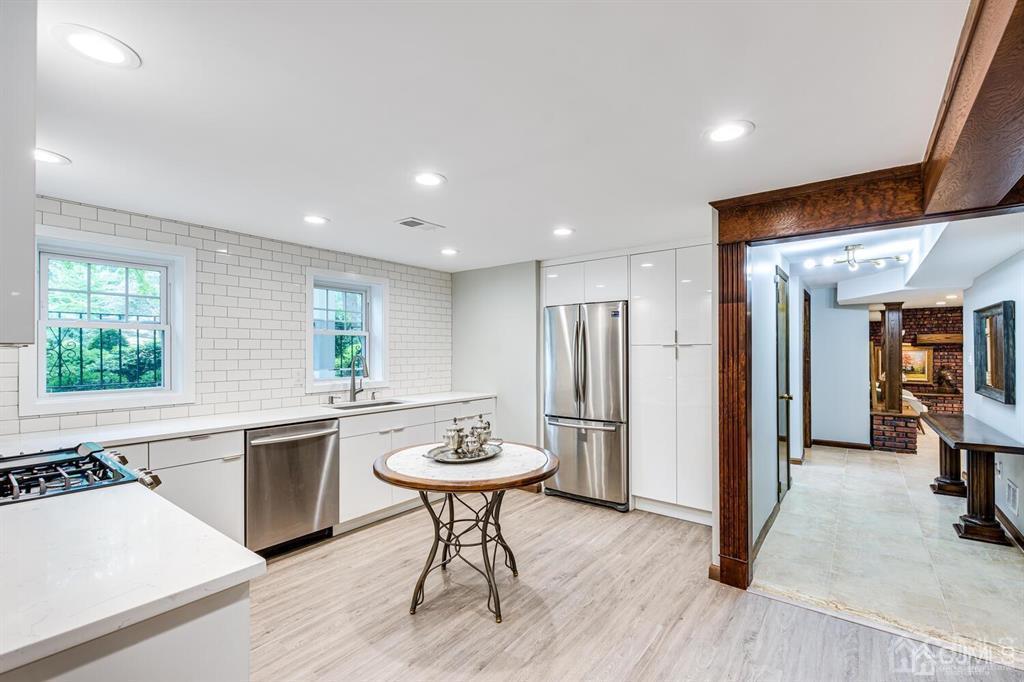 14 Tamarack Road Edison, NJ 08820 - Photo 34 of 40 a kitchen with a sink a refrigerator and chairs