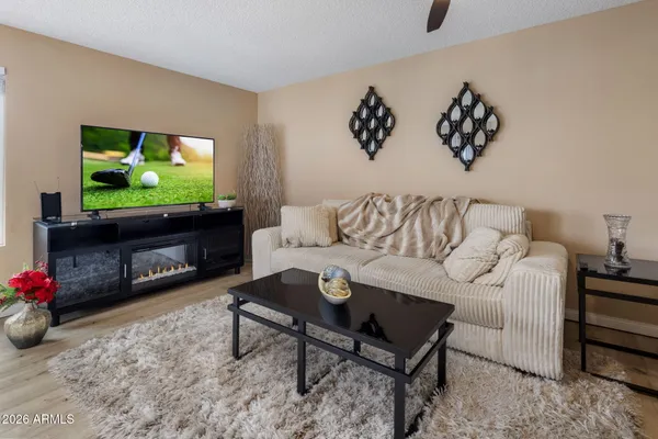 a living room with furniture a flat screen tv and a wall painting