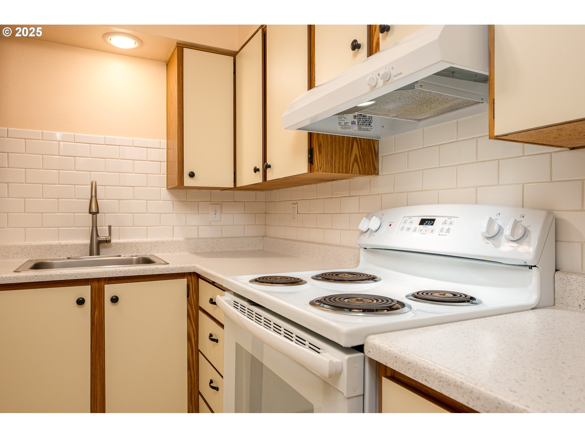 14828 Southwest 109th Avenue Portland, OR 97224 - Photo 16 of 40 a kitchen with a sink a stove and cabinets