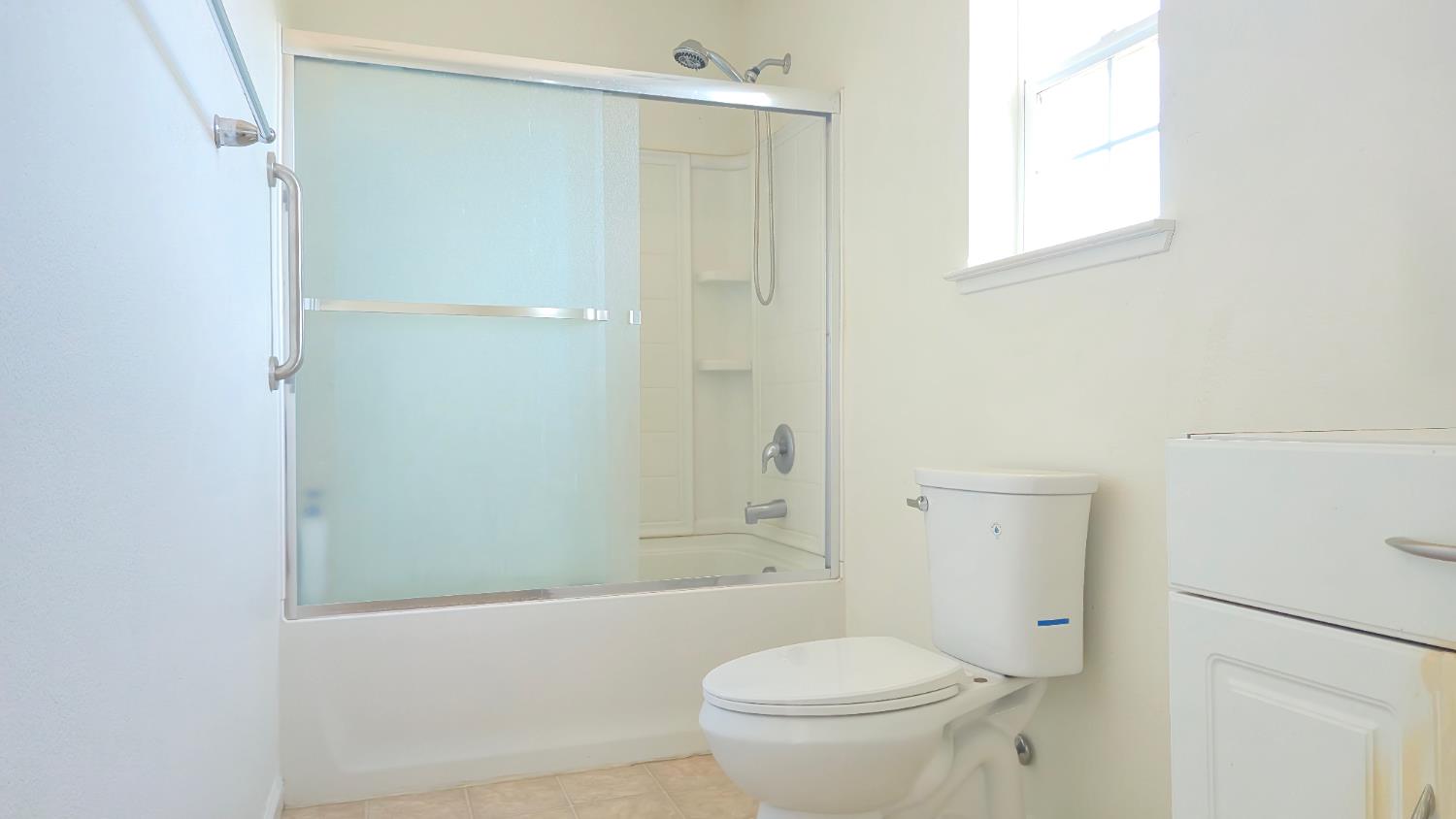 758 Persimmon Street Madera, CA 93638 - Photo 16 of 32 a bathroom with a granite countertop toilet a sink and shower