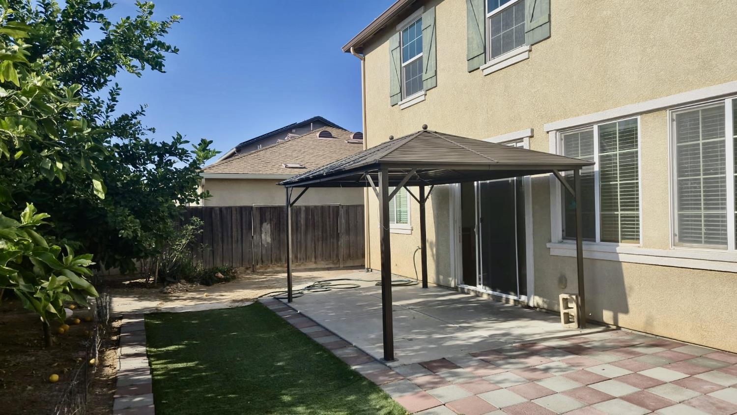 758 Persimmon Street Madera, CA 93638 - Photo 27 of 32 a view of a house with backyard sitting area and garden