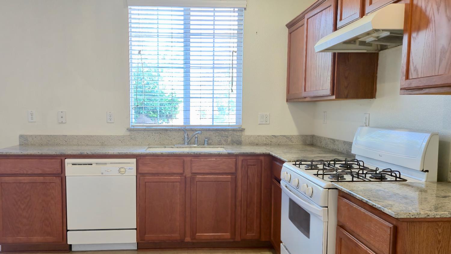 758 Persimmon Street Madera, CA 93638 - Photo 8 of 32 a kitchen with granite countertop a stove and a sink