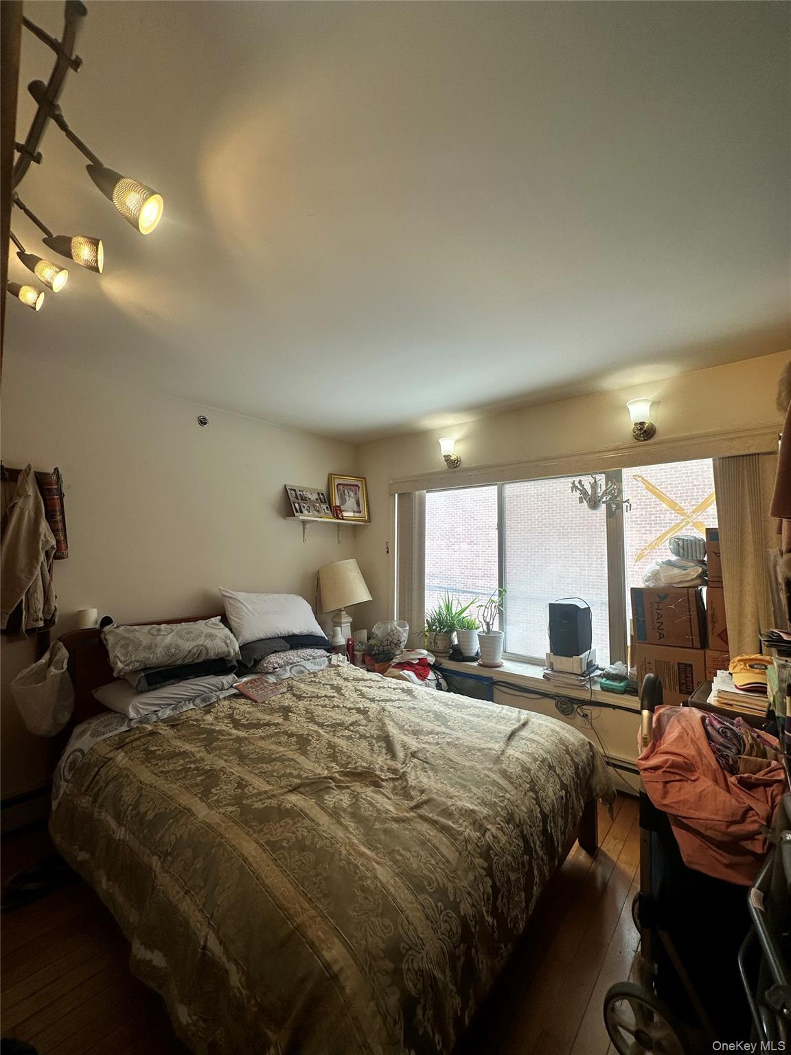 40-24 76th Street, Unit 3B Queens, NY 11373 - Photo 7 of 9 a bed sitting in a bedroom next to a window