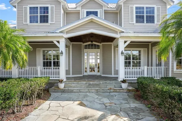 a kitchen with stainless steel appliances granite countertop a refrigerator a sink dishwasher a stove and a dining table with wooden floor