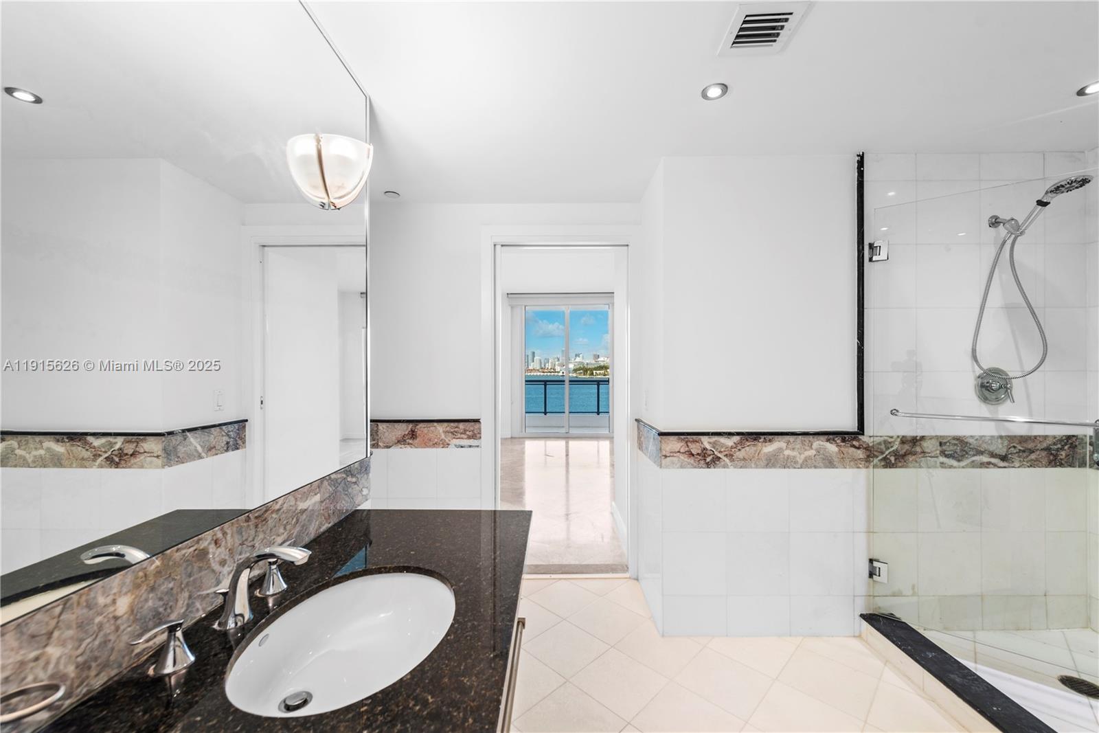 540 West Avenue, Unit 413 Miami Beach, FL 33139 - Photo 23 of 33 a bathroom with a granite countertop sink a mirror and shower