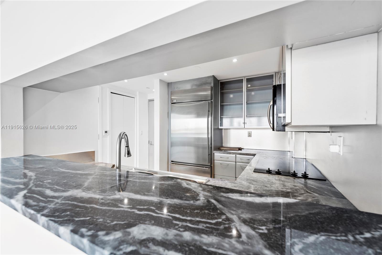 540 West Avenue, Unit 413 Miami Beach, FL 33139 - Photo 10 of 33 a kitchen with kitchen island granite countertop a sink and cabinets