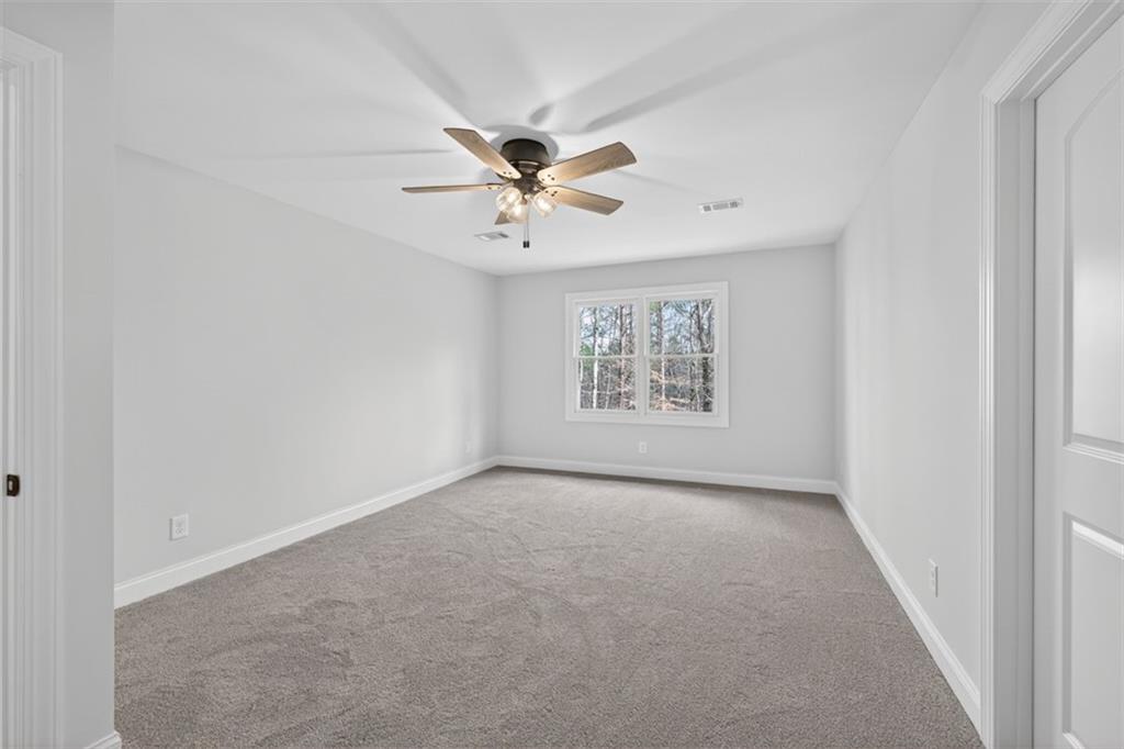 3110 Flatbottom Road Ball Ground, GA 30107 - Photo 50 of 89 an empty room with windows and chandelier fan