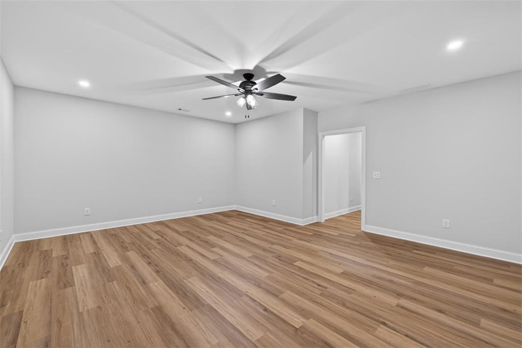 3110 Flatbottom Road Ball Ground, GA 30107 - Photo 59 of 89 a view of an empty room with chandelier fan and wooden floor