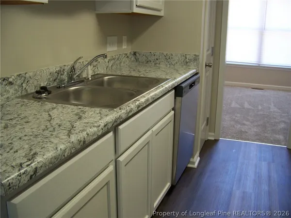 a kitchen with a sink and a wooden floor