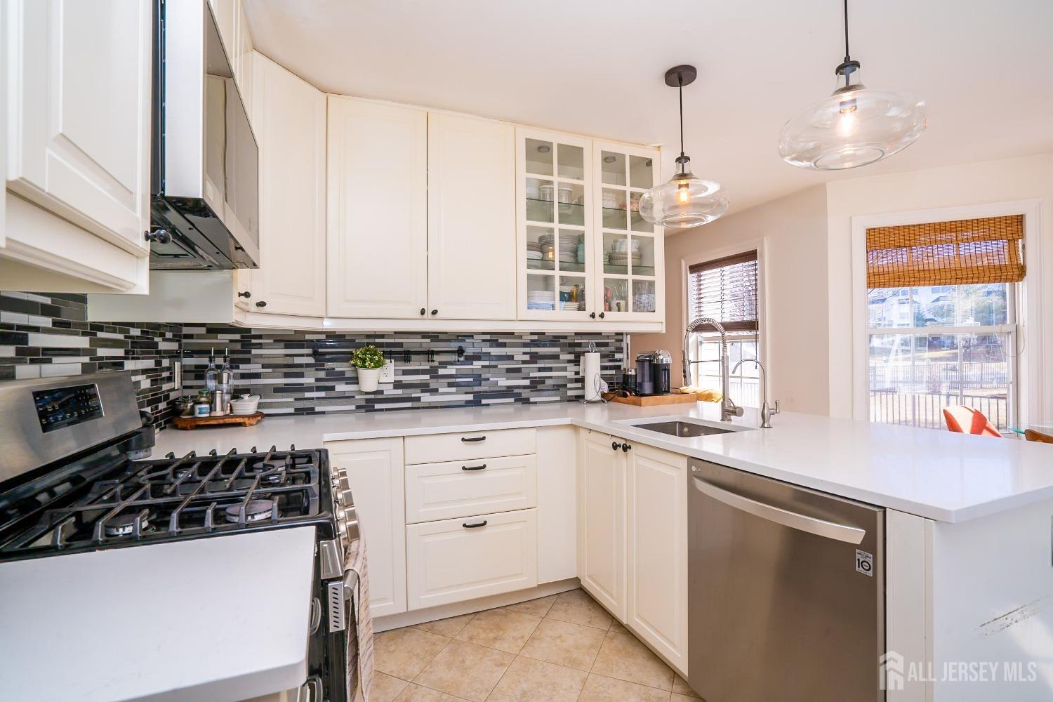 43 Springfield Road North Brunswick, NJ 08902 - Photo 18 of 48 a kitchen with stainless steel appliances a stove a sink and white cabinets
