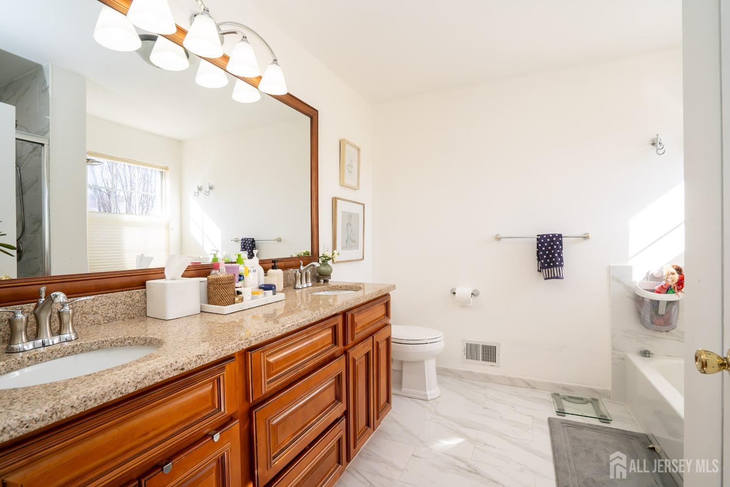 43 Springfield Road North Brunswick, NJ 08902 - Photo 29 of 48 a bathroom with a granite countertop sink a large mirror and a toilet