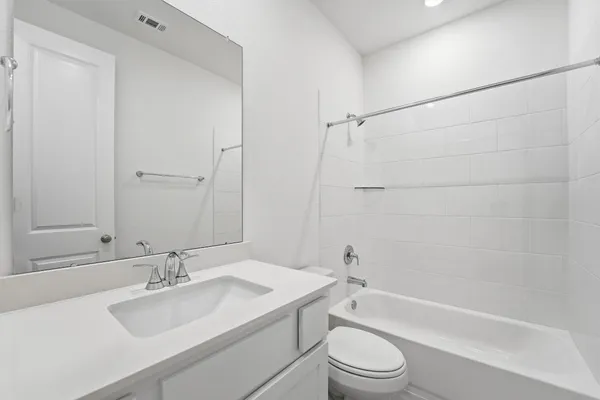 a bathroom with a sink toilet vanity and shower