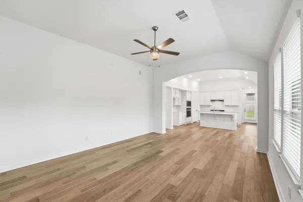 a view of a kitchen with wooden floor a sink and a window