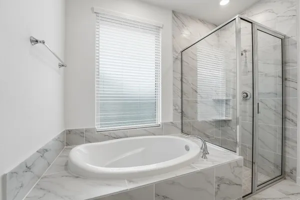a white bath tub sitting next to a shower