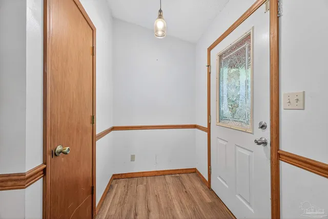 a view of a hallway with wooden floor and a window