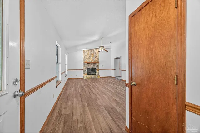 a view of a hallway with wooden floor and staircase