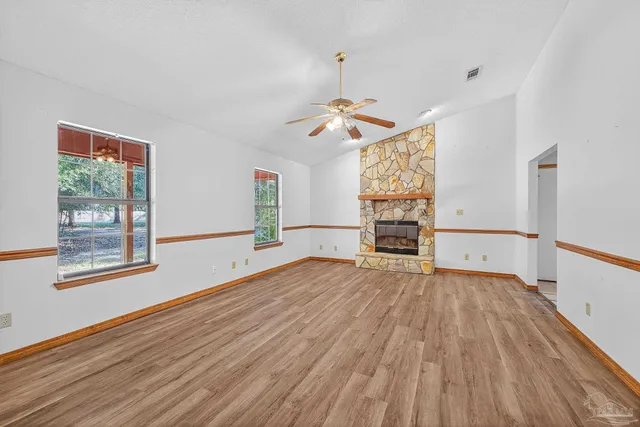 a view of empty room with wooden floor and window