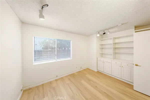 a view of an empty room with cabinet and a window