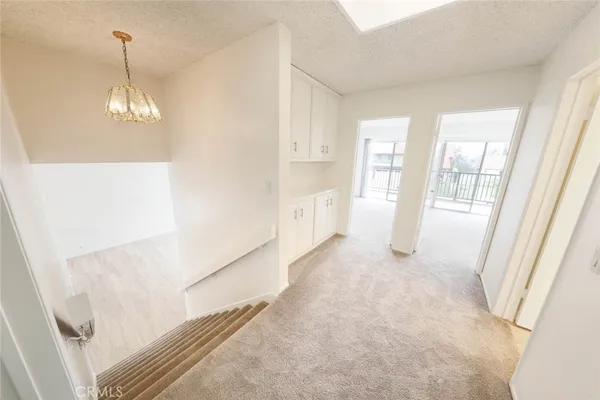 a view of an empty room and a kitchen