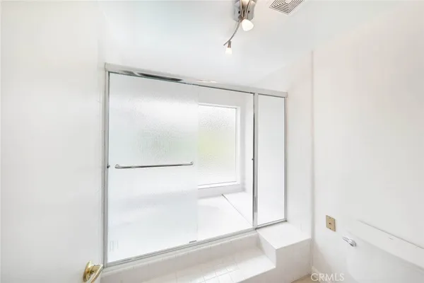 a bathroom with a glass shower door