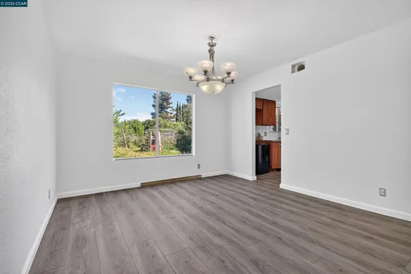 an empty room with wooden floor and ceiling fan