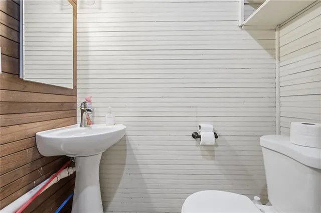 a bathroom with a sink a toilet and mirror