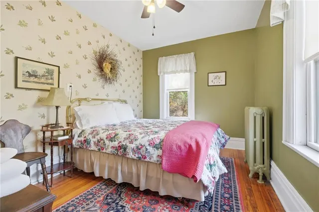 a bedroom with a bed wooden floor and window