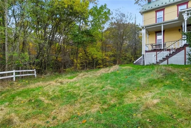 a backyard of a house with lots of green space and fountain