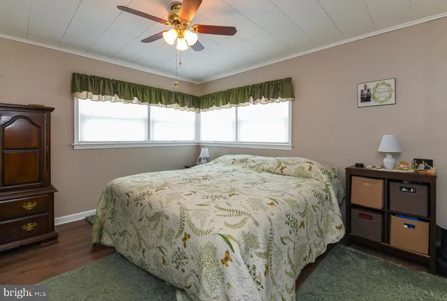 a bed sitting in a spacious bedroom next to a window