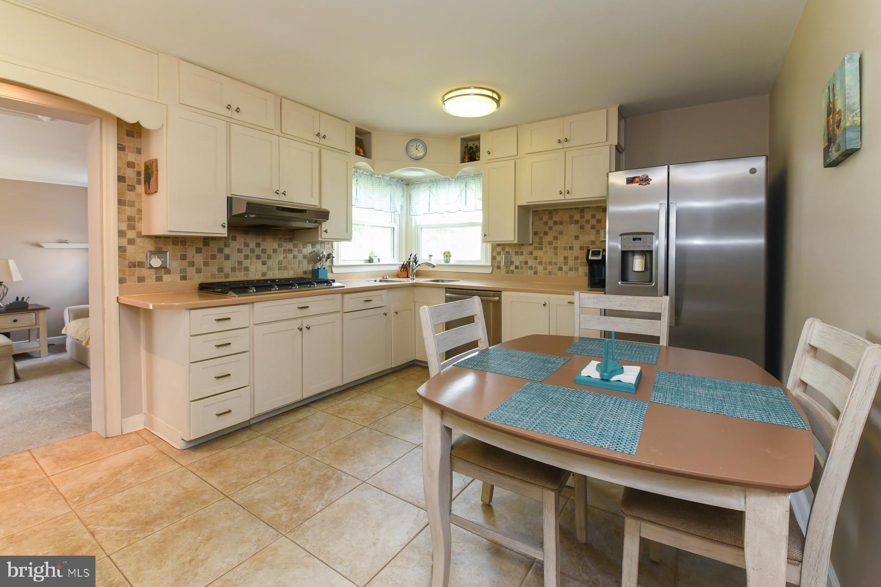 21 Hiawatha Road Somerdale, NJ 08083 - Photo 9 of 22 a kitchen with stainless steel appliances granite countertop a sink a stove a refrigerator cabinets and chairs