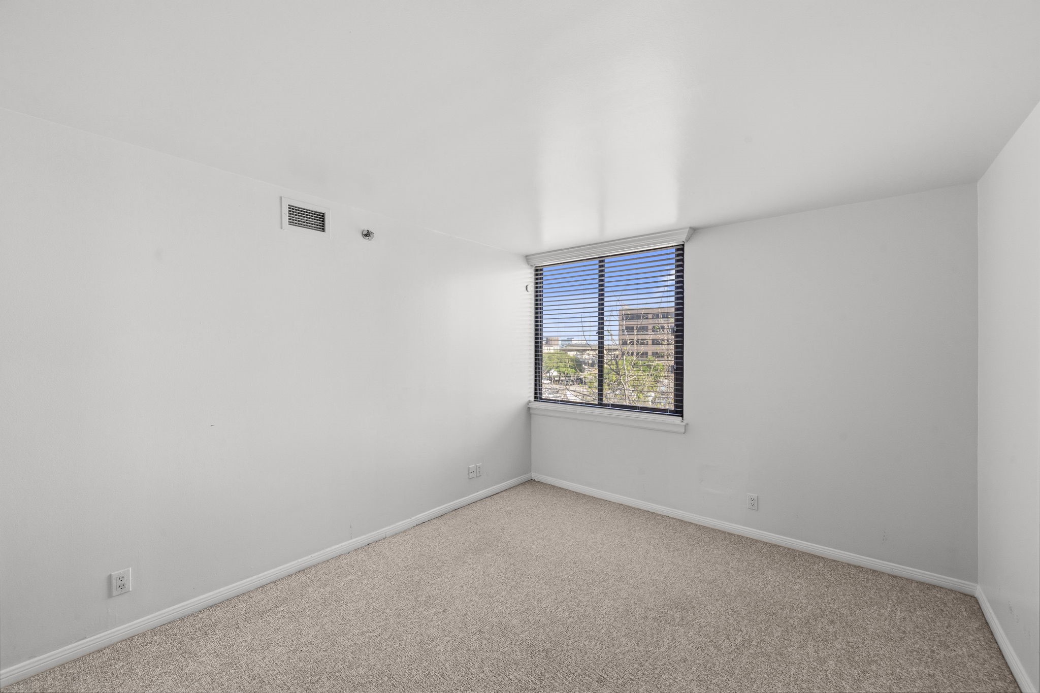 3525 Sage Road, Unit 504 Houston, TX 77056 - Photo 12 of 18 Spacious secondary bedroom featuring a large window with privacy blinds, and carpet floors.