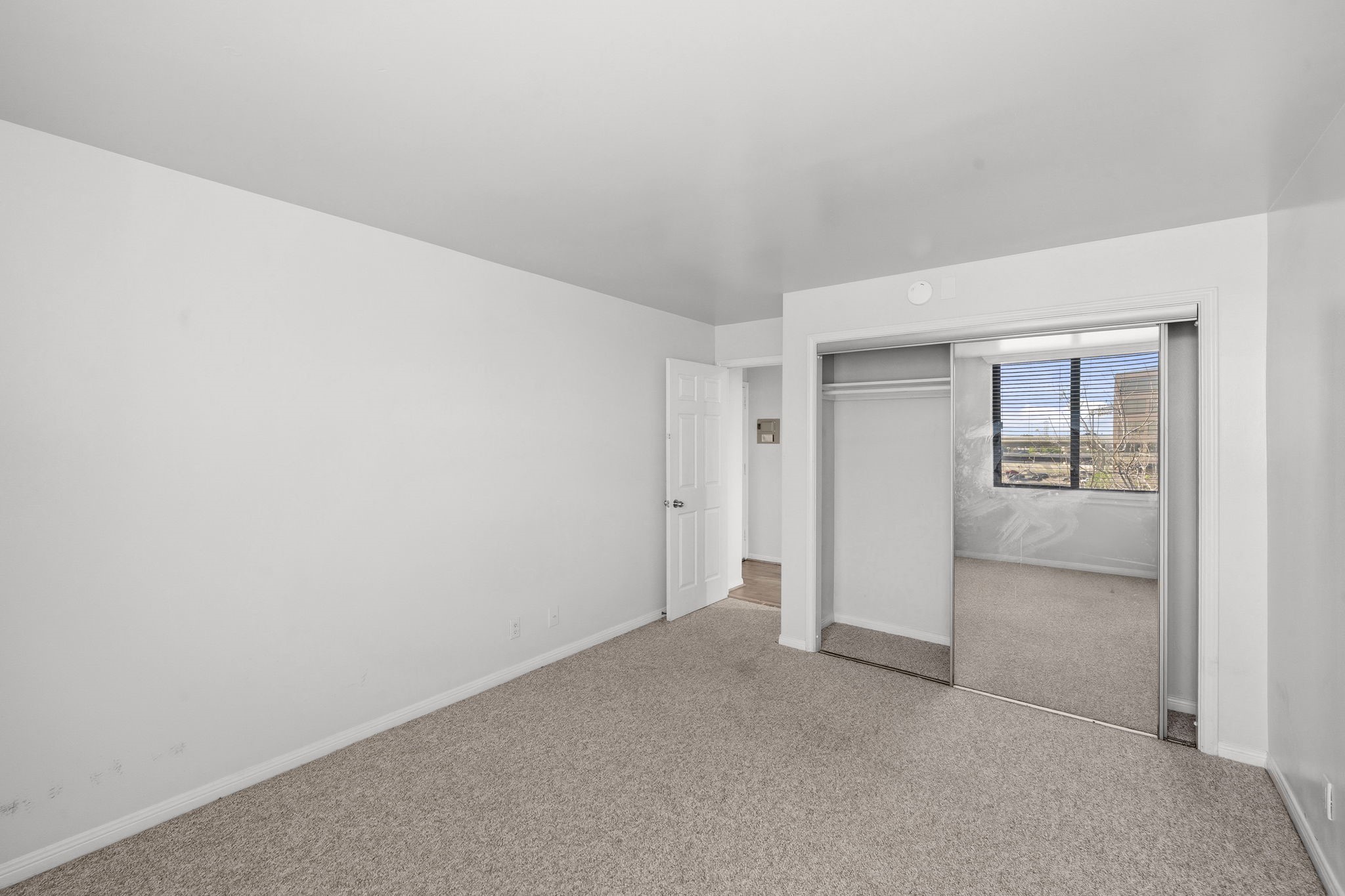 3525 Sage Road, Unit 504 Houston, TX 77056 - Photo 13 of 18 Another view of the secondary bedroom, featuring a mirrored closet door that adds both functionality and a heightened sense of space.