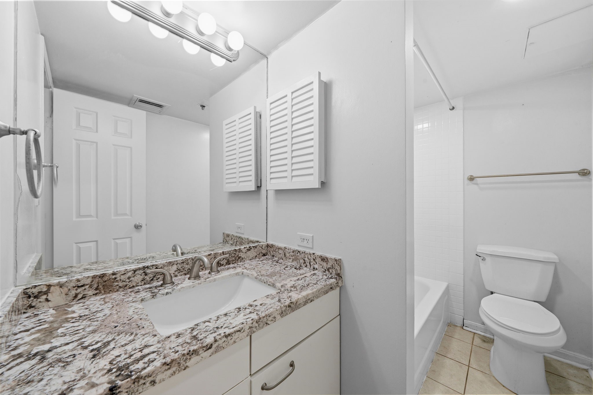 3525 Sage Road, Unit 504 Houston, TX 77056 - Photo 14 of 18 Secondary bathroom, featuring tile floors, cabinets, granite countertops, and a large mirror.