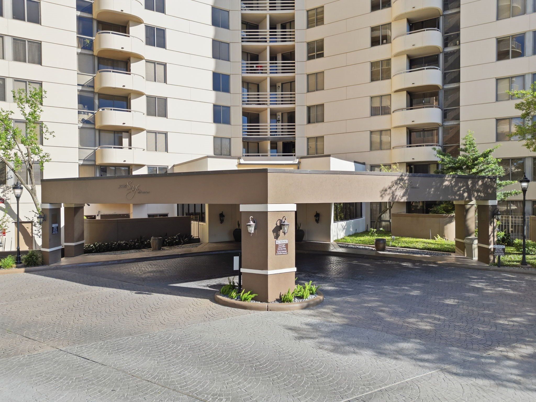 3525 Sage Road, Unit 504 Houston, TX 77056 - Photo 18 of 18 A wide-angle ground-level shot focusing on the grand porte-cochère. The distinctive brown-and-tan color palette and large pillars highlight the prestigious entrance.
