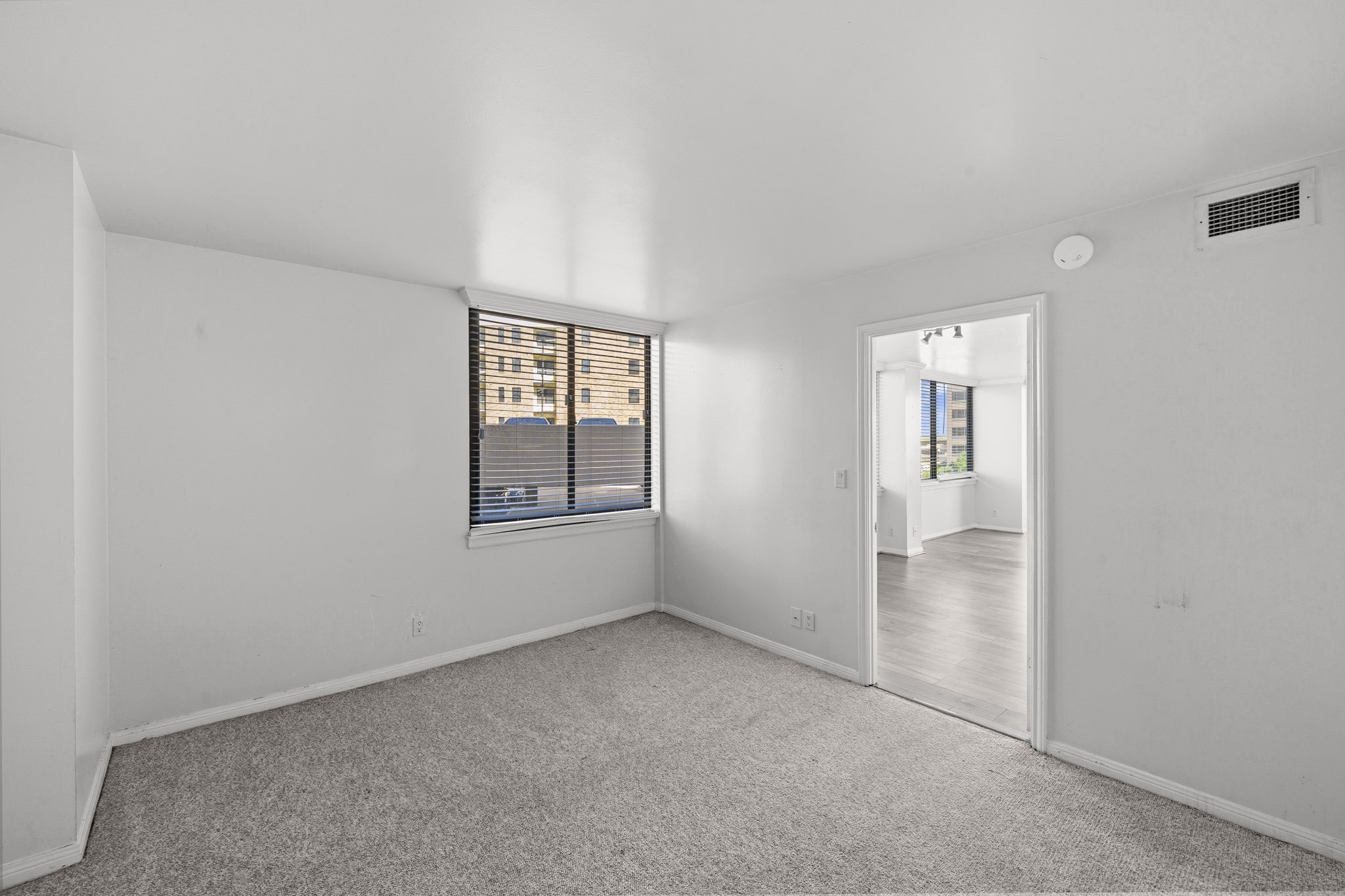 3525 Sage Road, Unit 504 Houston, TX 77056 - Photo 8 of 18 The primary bedroom filled with natural light, featuring a well-placed window with privacy blinds for comfort and tranquility.