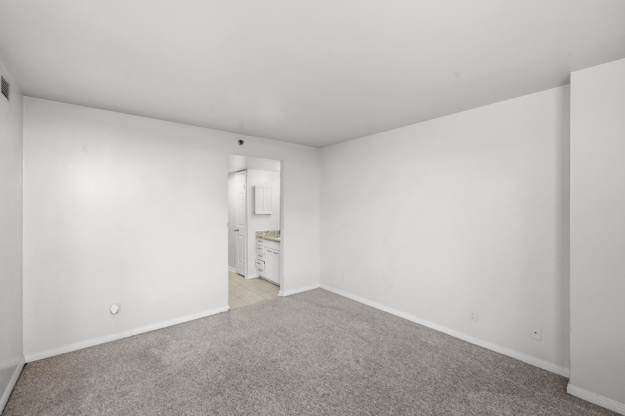 3525 Sage Road, Unit 504 Houston, TX 77056 - Photo 9 of 18 A primary bedroom offering direct access to the bathroom, featuring plush carpeting and generous space for comfort and relaxation.