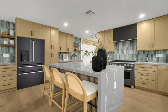 a kitchen with a refrigerator and a stove top oven