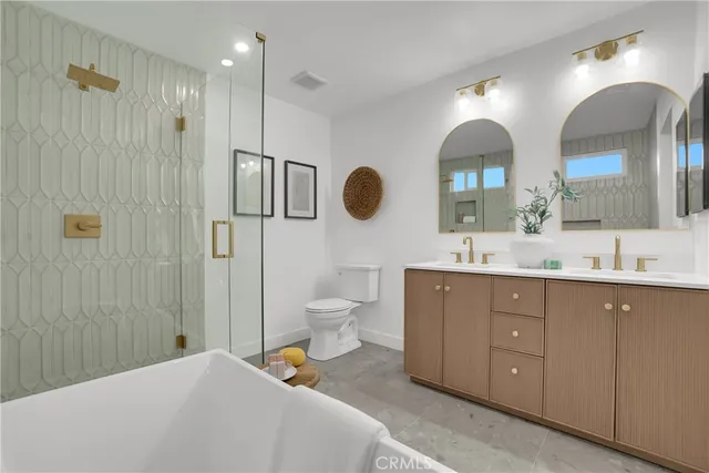 a spacious bathroom with a double vanity sink toilet mirror and shower