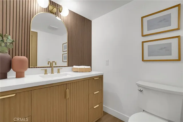 a bathroom with a granite countertop sink mirror vanity and toilet