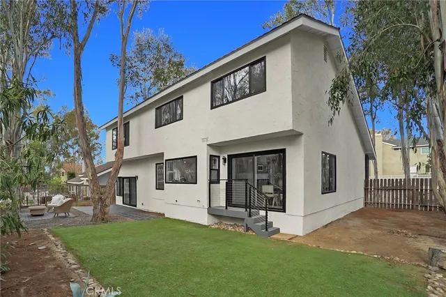 a view of a house with backyard and a tree