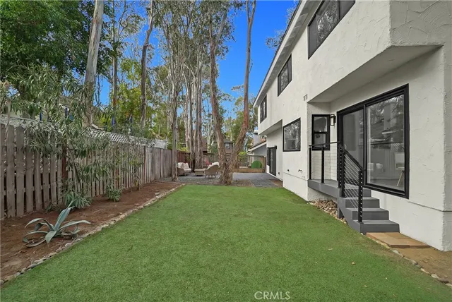 a view of a patio with a table and chairs and wooden fence